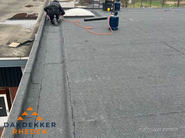 Dakdekker repareert bitumen dakbedekking op groot plat dak in Rheden Dakdekker repareert bitumen dakbedekking op groot plat dak in Rheden